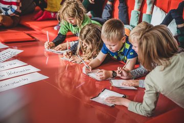 Kinder schreiben und malen auf einem Tisch