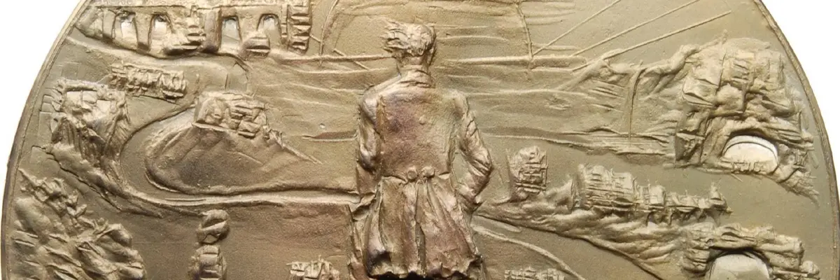 Eine Medaille, die einen Wanderer auf einem Felsen ins Tal blickend abbildet.