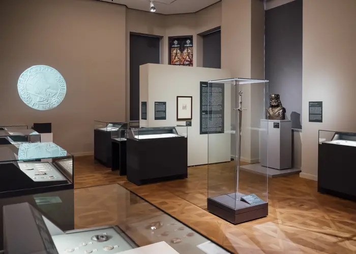 Ausstellungsraum mit Vitrinen und einer Wandprojektion