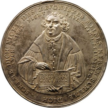 Medaille, darauf Luther, der ein Buch hält